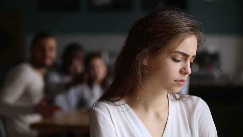 Sad offended teen ignoring friends apologizing for bad joke, upset depressed young woman suffering from community discrimination friends bullying gossiping, drama girl sulking for lack of attention | Shutterstock HD Video #1022373397