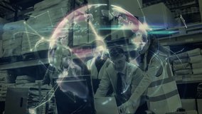 Low angle view of warehouse workers wearing safety gear discussing plans in warehouse while looking at computer screen with digital globe forming on screen  - Powered by Shutterstock - Get 15% off with code: PIKWIZARD15