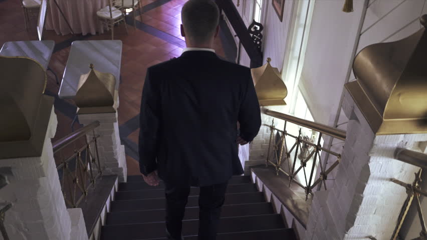 Man in black suite is walking down the stairs. Gala event, shoe, celebration. 