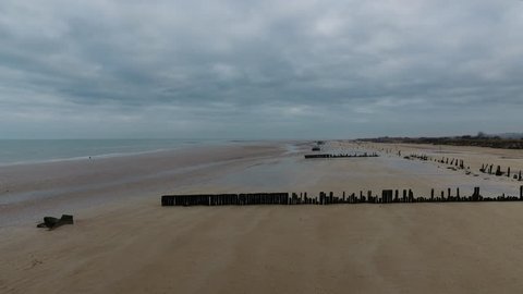 D-Day Landing Beach in Arromanches France Normandy aerial drone shot. Cloudy day endless landscape
