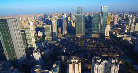 Aerial view of Chengdu City in the morning sunlight, dense residential building near the office building under the blue sky, the Taikoo Li Mall area with traditional Asian style building.
