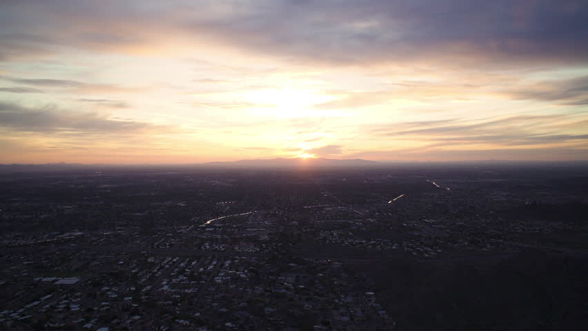 Time lapse of sunset over Phoenix, Arizona from mountain with purple sky and colorful clouds.