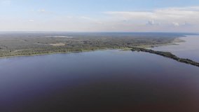 Drone video. Natural landscape. Narrow long sandy island between two reservoirs. 
