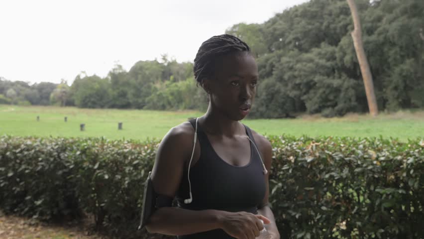 black Female Jogger Drinking Water In The park-slow motion