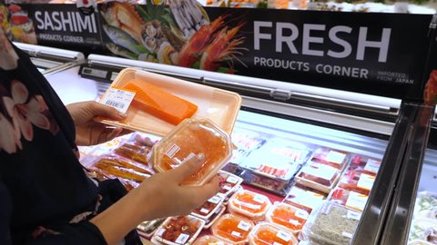 Female Customer Buying Salmon Fish And Red Caviar In Supermarket.