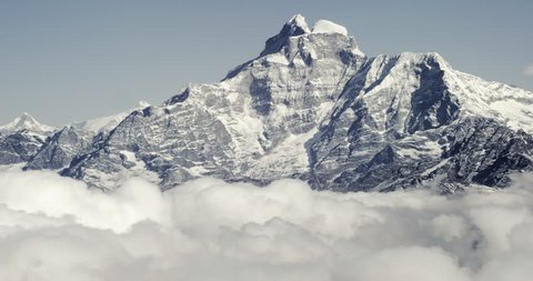 Mount Everest epic aerial wide shot panoramic view of snowcapped cold rocky mountains with clouds in Nepal near tibet with cloudy skies and fierce winds.