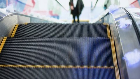 Shot of young man without bag moving on escalator, goes up the escalator in a big business center. Rush hour, subway underground station. Modern escalator stairs moving up.