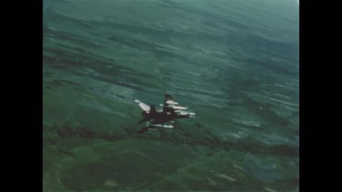 CIRCA 1965 - Footage shot from the head of a USAF plane shows it firing on an enemy camp in Vietnam.