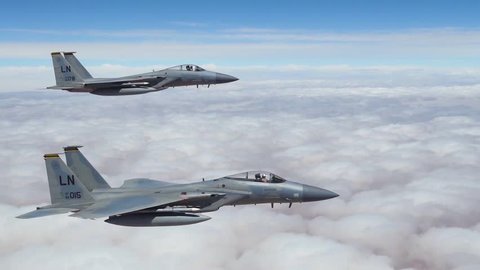 CIRCA 2018 - American F-15 fighter jets fly in formation high above the clouds.