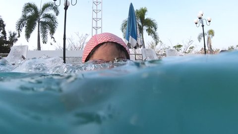 Cute girl diving under the water in the swimming pool. An underwater shot