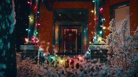 Snow falling outside of house with Christmas lights and wreath - Powered by Shutterstock - Get 15% off with code: PIKWIZARD15