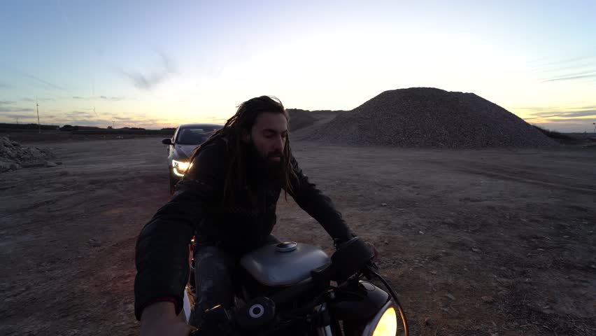 Man with dreadlocks riding on his motorcycle taunts police