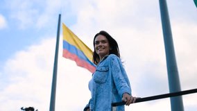 Happy girl smiling and posing in front of the Colombian flag in Medellin, Tourist Caucasian pretty girl smiling in front of the flag - Powered by Shutterstock - Get 15% off with code: PIKWIZARD15