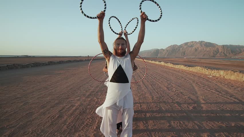 Man in foreground with group shows rings performance shaky footage slow motion