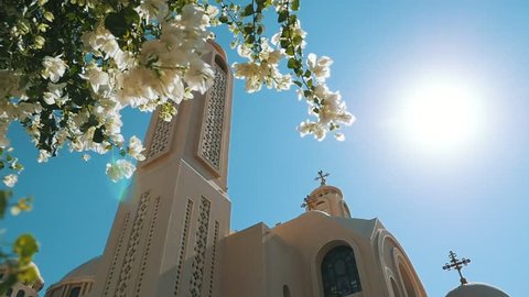 Sharm el Sheikh, Egypt - October24, 2018: Beautiful view of Coptic Christian Church of Sharm-el-Sheikh with spherical domes and blossoming trees in Egypt on a sunny day in slow motion