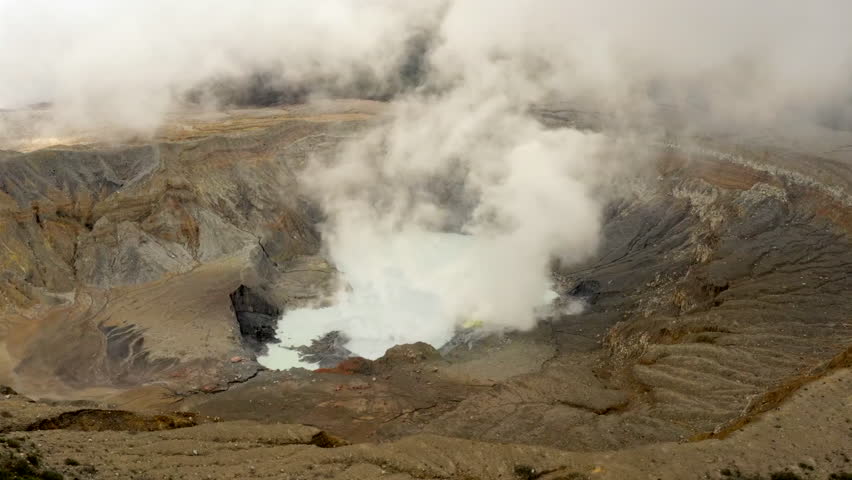 Aerial: Enormous Crater of Volcano Surrounded by Mist and Clouds