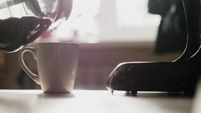 The girl pours a white Cup of freshly brewed coffee from the glass bowl coffee makers. Early in the morning before work, fresh coffee - Powered by Shutterstock - Get 15% off with code: PIKWIZARD15