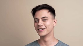 Pretty young guy smiles and laughs to the camera in slow motion, video portrait of a man, selfie video portrait, blogger smiles