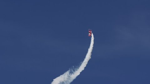 Air show, bright red Pitts S1-E biplane aerobatic plane in the blue sky. Gelnhausen, Germany, slow motion, June 2017