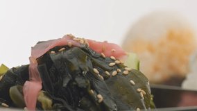 panned video moving from salad to three onigiri rice ball
