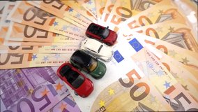 VIDEO, small model cars rotating on cash euro banknotes
