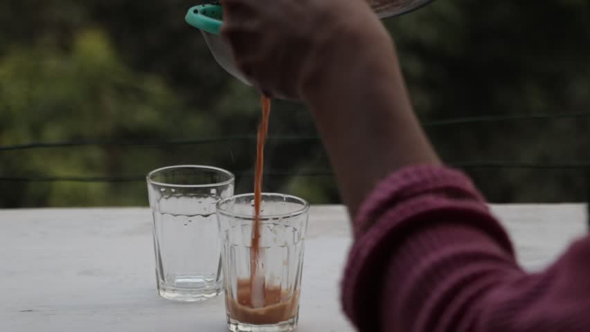 footage of tea getting filed in a glass at oudoor