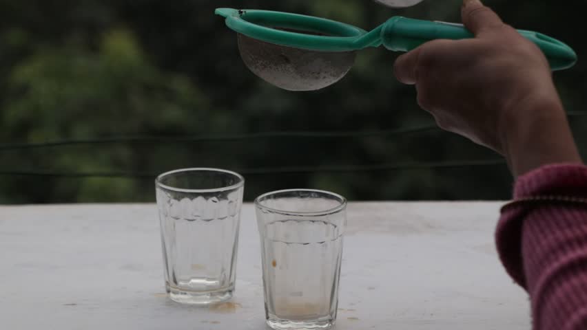 footage of tea getting filed in a glass at oudoor