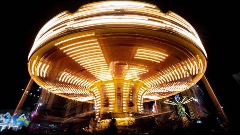 Merry-go-round carousel at night. Amusement park carousel with beautifully painted wooden horses.