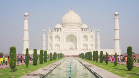 Agra, India - 8 November, 2018: Wonderful view of the Taj Mahal on blue sky background. White marble mausoleum reflected in artificial pool. The Taj Mahal is a popular tourist attraction of South Asia