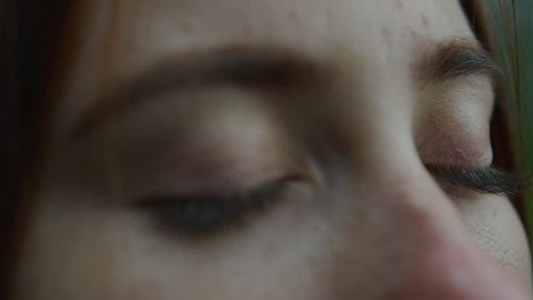 Close up view of a girl with freckles and blue eyes.