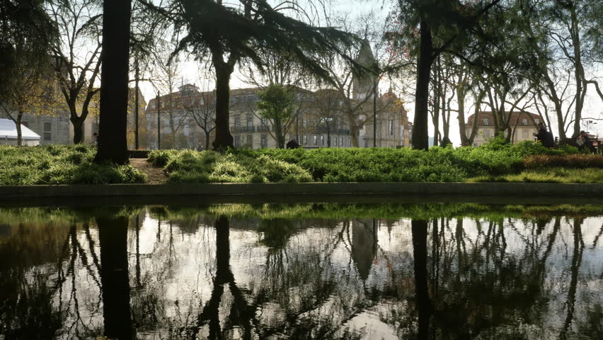 Water Reflection Jardim Cordoaria Garden In Porto, Portugal. Pond water reflecting the garden of Joao Chagas, popularly known as Jardim da Cordoaria in the city of Porto, in Portugal