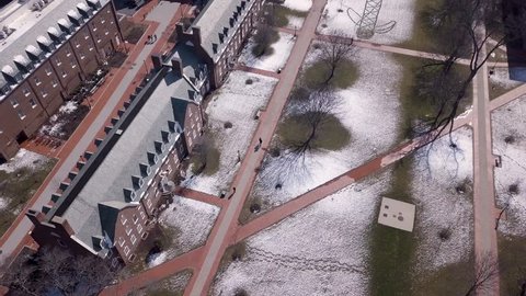 Students walk through snow at University of Delaware college campus aerial