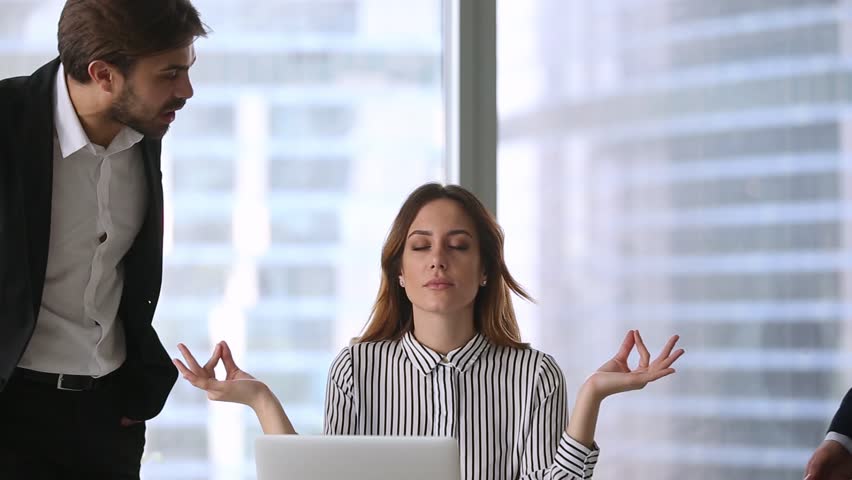 Calm businesswoman professional taking break meditating at work ignoring angry colleagues disturbing clients, mindful healthy female boss doing yoga feeling no stress zen balance at office workplace Royalty-Free Stock Footage #1022497315