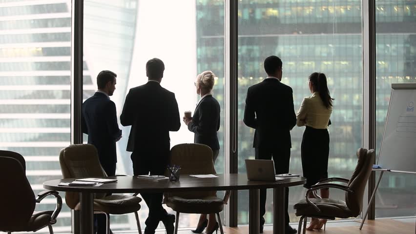 Diverse multi ethnic employees group stand separately talking at work in modern boardroom skyscraper office, racial segregation discrimination prejudice problem at workplace concept, rear back view
 Royalty-Free Stock Footage #1022497324