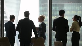 Rear back view of diverse colleagues group talking at work break, international business people silhouettes have corporate discussion near window, racial segregation discrimination in office concept  - Powered by Shutterstock - Get 15% off with code: PIKWIZARD15
