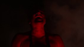 Video clip man demonically laughs, performs a ritual in the light of fire at night in the dark 