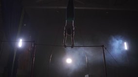 Gymnast exercises on high horizontal bar HD slow-motion video. Athlete training gymnastics skills and performing giant elements