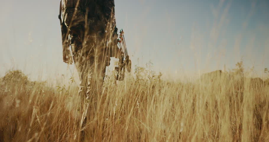 A bowhunter walks through golden grass Royalty-Free Stock Footage #1022504584