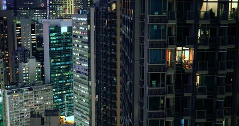 Modern city downtown at night. Apartments, condos and office buildings illumination in Hong Kong aerial view