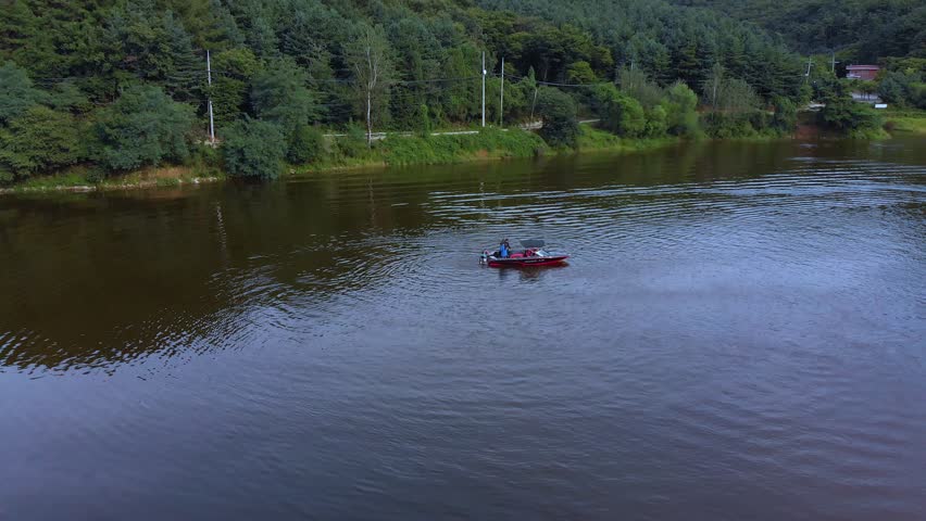 Aerial view of a person getting on a small boat after doing jet ski