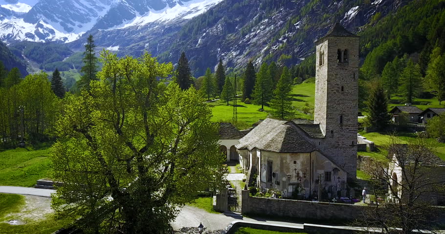 Aerial shot of catholic medieval church in the rural alps of Italy.