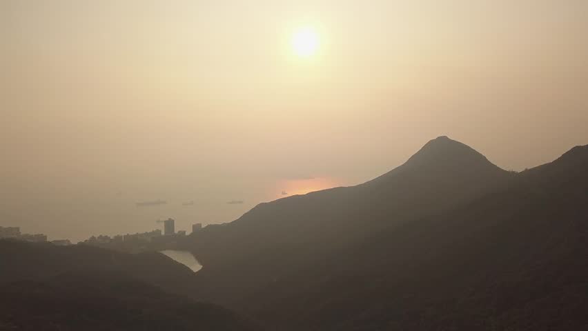 Tilt High-Rise over Hong kong china over Hotels and Residential Apartment Tower and Buildings at sunset from mountain view