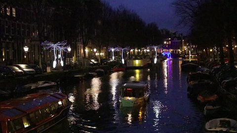 Amsterdam, Netherlands - January 05 2019: Light installation in the form of large dandelion seeds suspended above a canal during a festival of light