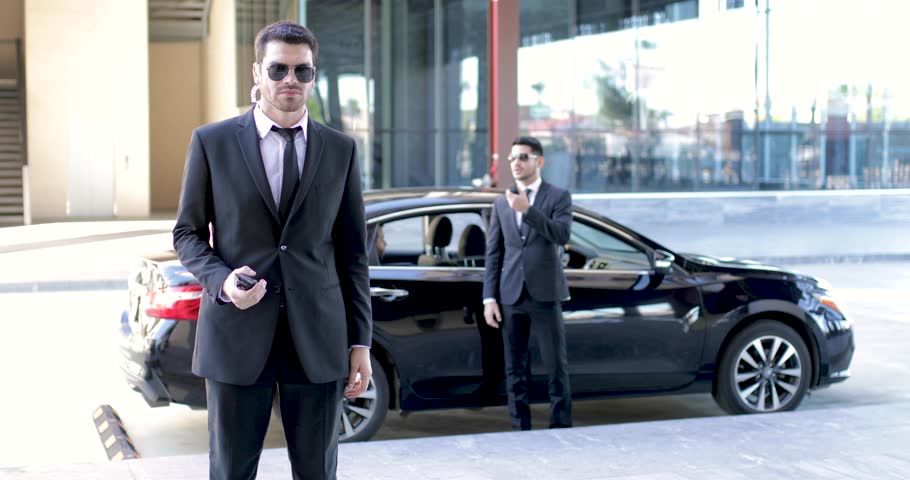 Security team escorting and protecting an important businessman out of a car and into a building Royalty-Free Stock Footage #1022552326