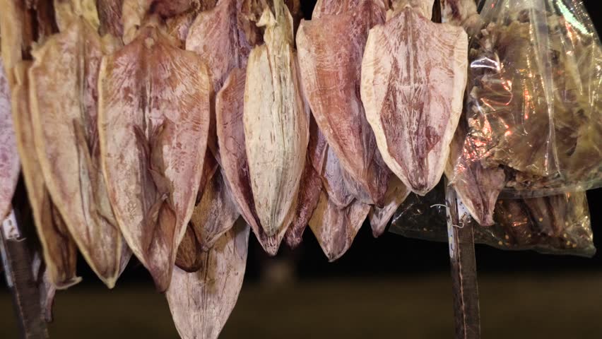 A bunch of squid dries against the night sky.