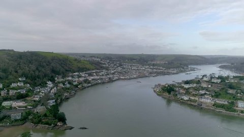 Aerial vista of the town of Dartmouth, UK. Tracking backwards slowly, a lively view of the town is shown on a Winter day. Clear and cloudy.