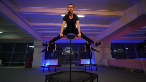 JUMPING FITNESS: Beautiful girls are jumping on a fitness trampoline. Slender girls perform exercises on trampolines. Fitness exercises for a beautiful and slim figure