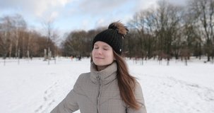 4K Footage of happy young girl walking and jumping on the park with snow and sun shine weather. 