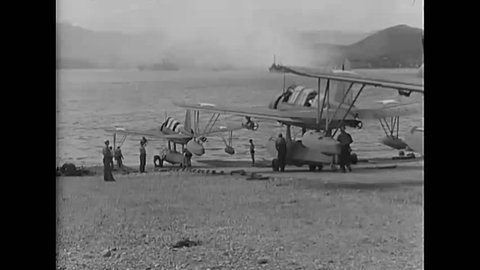 CIRCA 1940s - Vought OS2U Kingfisher floatplanes move down a ramp and taxi across a harbor and a pilot is shown in the cockpit of a warplane.