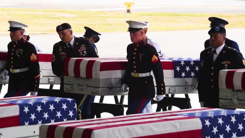 USA, CIRCA 2018 - flag draped coffins of dead U.S. soldiers being returned home are displayed in a military hangar.